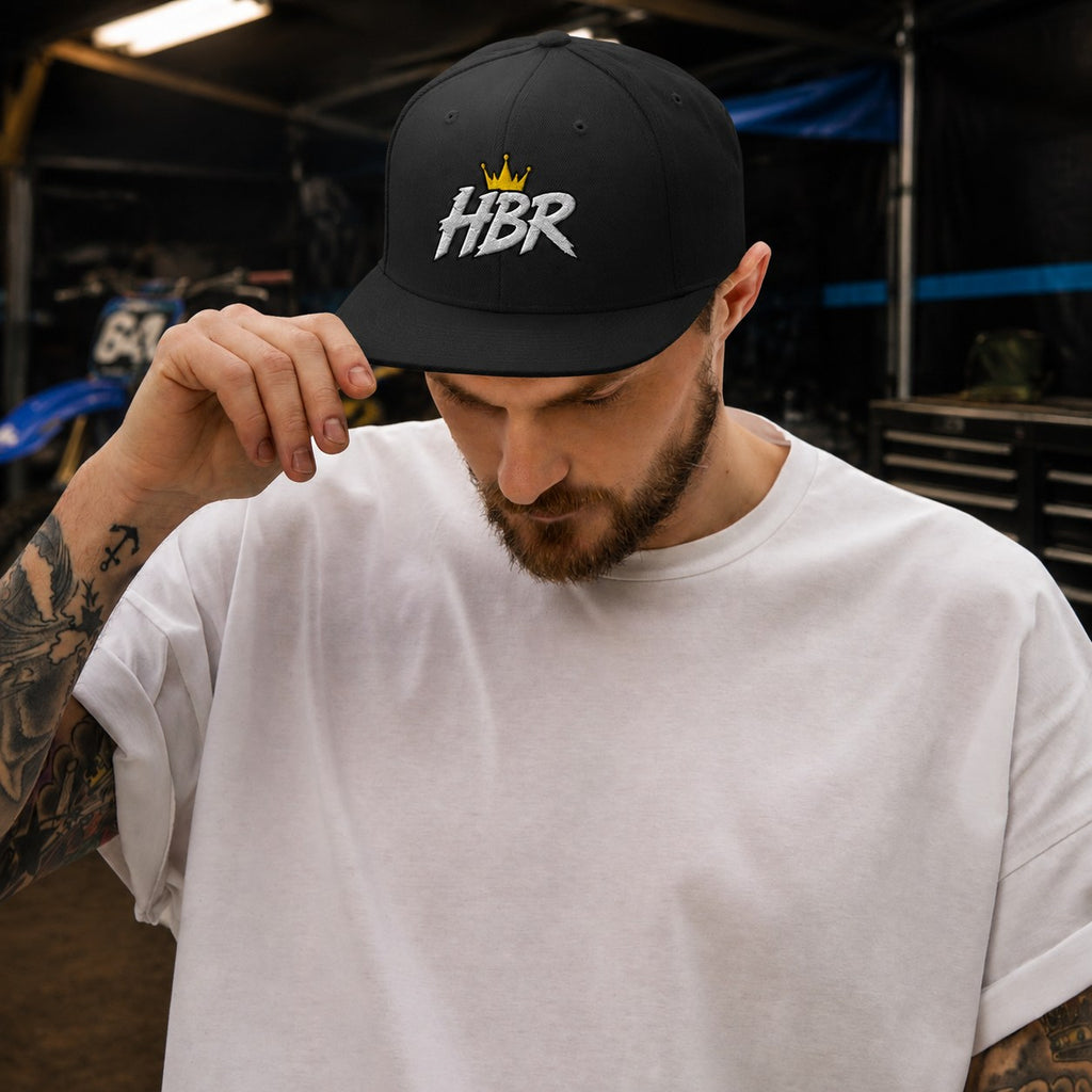 Hollar Built HBR Crown Logo Snapback worn naturally in a realistic HBR garage setting